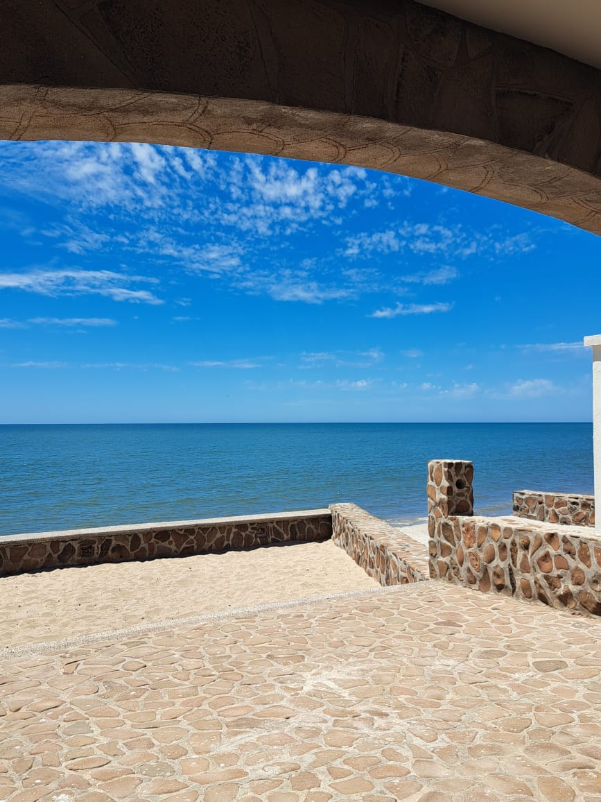 The beach house patio at Las Bocas, looking through a stone arch to the Sea of Cortez